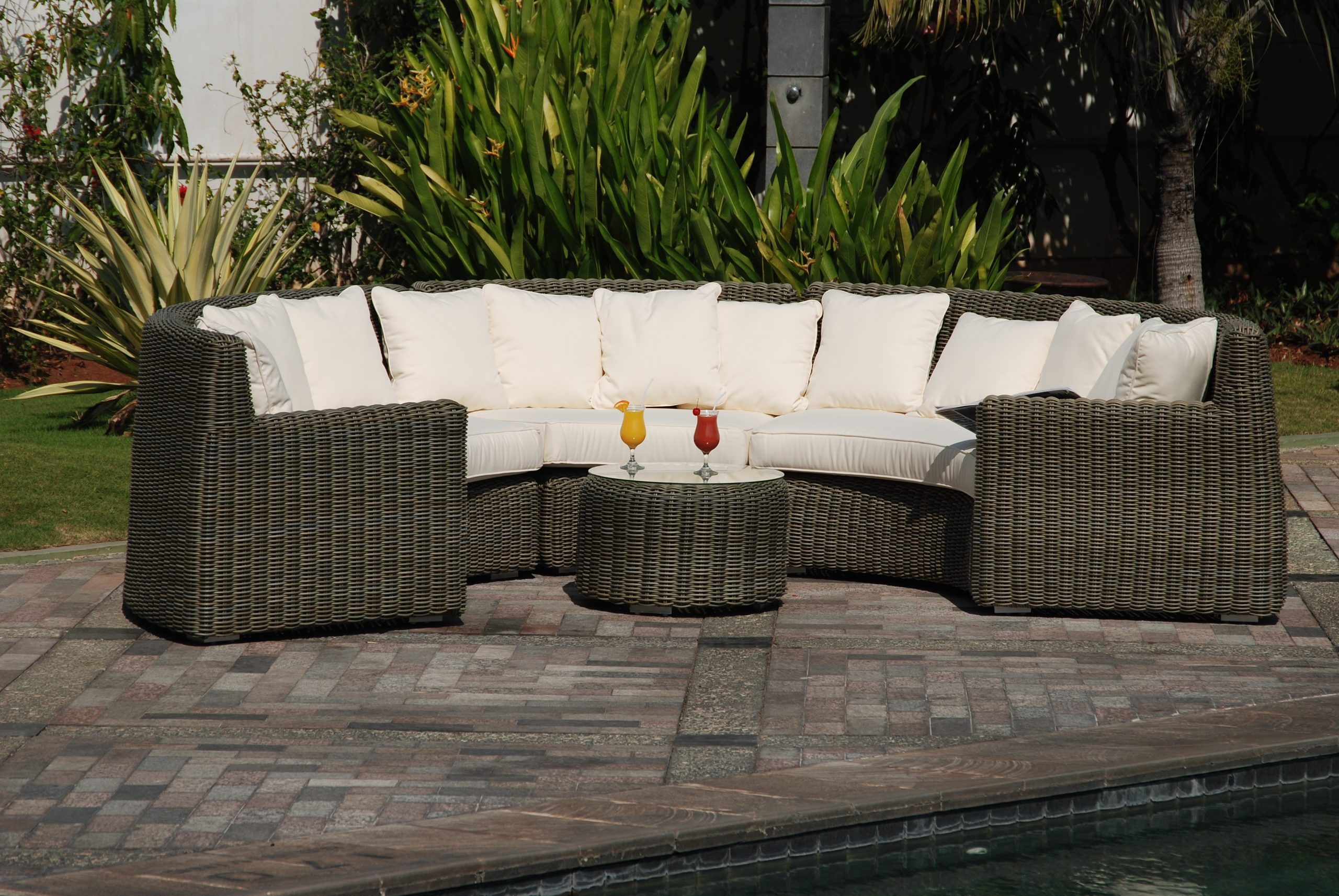 an outdoor wicker couch with thick white cushions